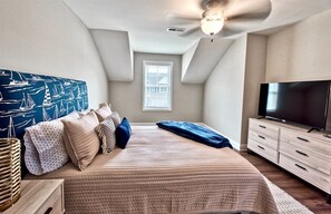A bedroom with a bed, a TV, a ceiling fan, and a window. - Coastal Club * 5 BR w 2.5 Bath Beach House (Lewes)