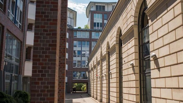 A corridor with brick and stone buildings, large windows, and a clear sky. - Deluxe Studio in Berlin Mitte (Berlin)