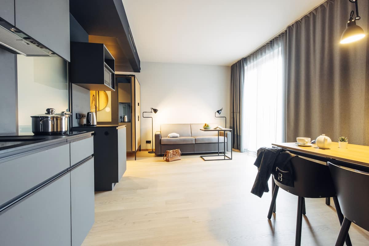 Eine moderne Küche mit Essbereich, einer Couch und einem Tisch mit Lampe.
