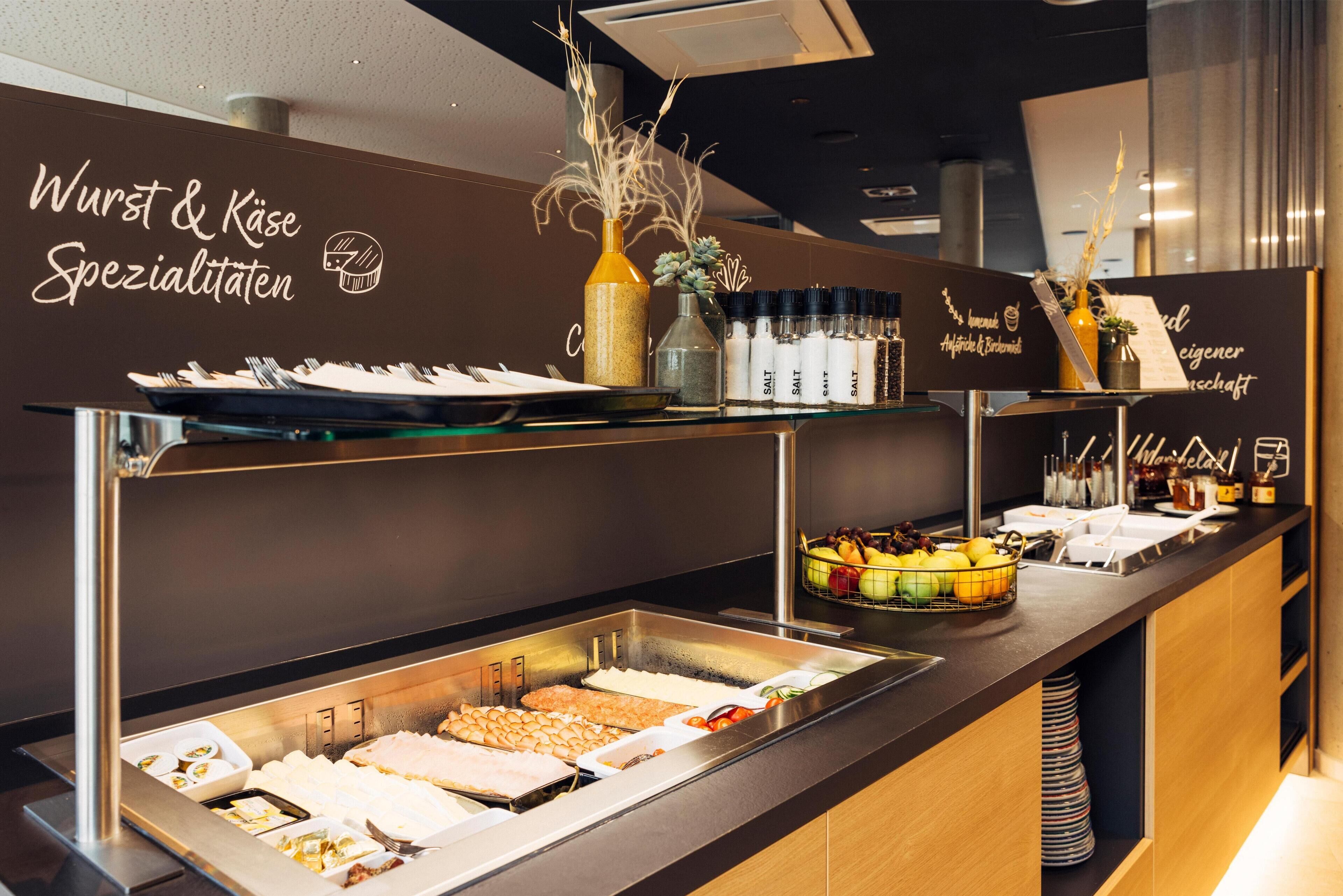 A buffet area with various food items and condiments.