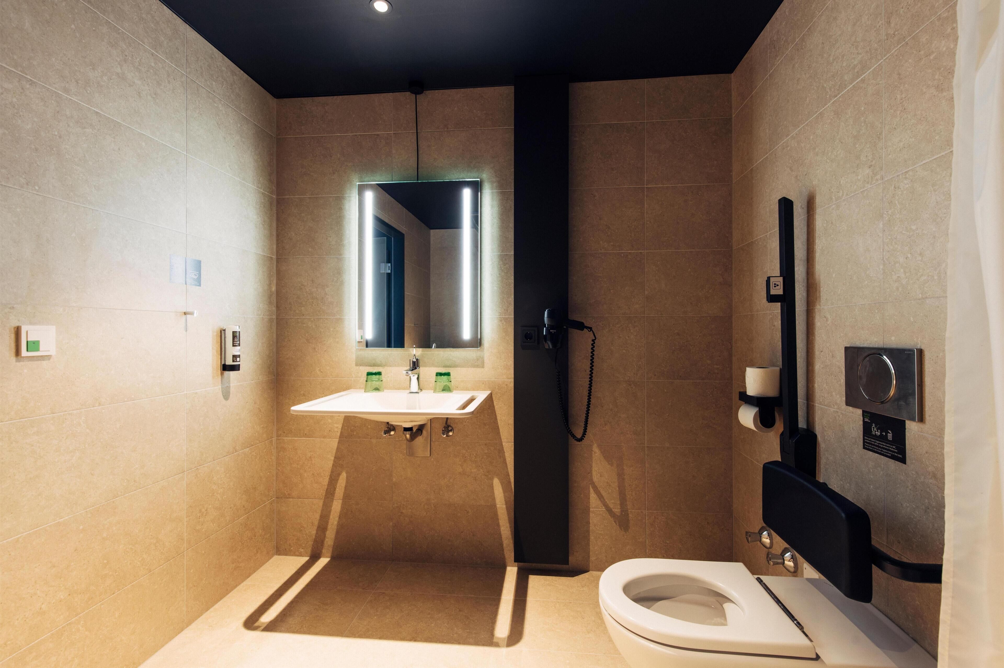 Un baño moderno con inodoro, lavamanos y ducha.