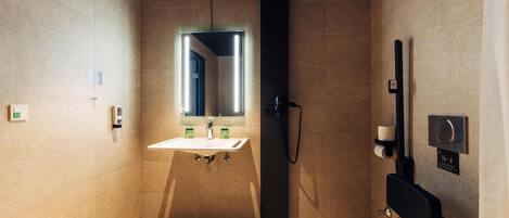 Un baño moderno con inodoro, lavamanos y ducha.