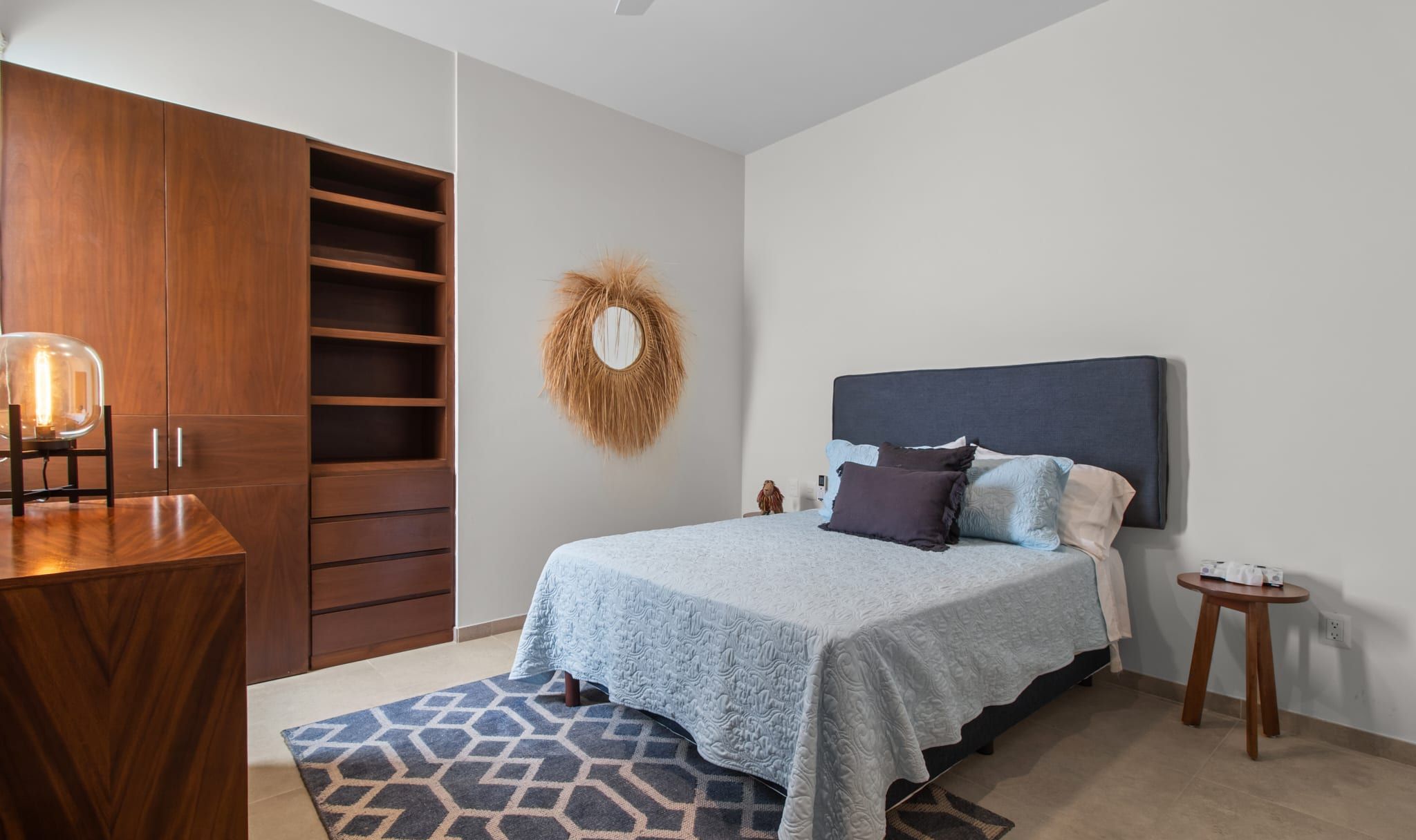 Un dormitorio con cama, mesita de noche y armario.