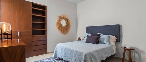 Un dormitorio con cama, mesita de noche y armario.