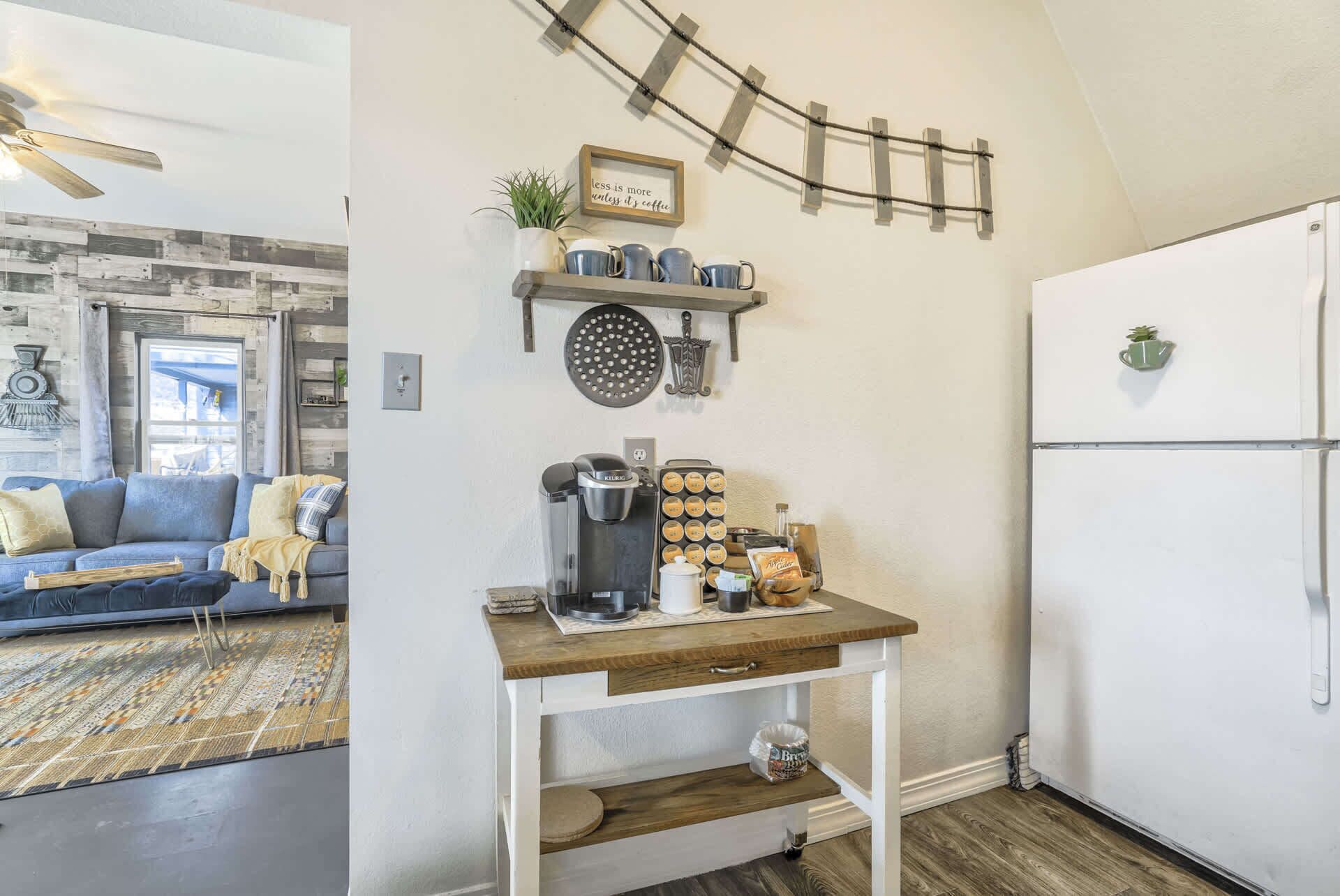 A compact kitchen with a coffee maker, a kettle, and a coffee grinder on the counter.