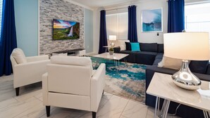 Uma sala de estar moderna com televisão de tela plana, sofá, mesa de centro e abajur.