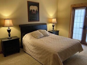 Cozy retreat with a large bed, nightstands, and a framed artwork above.