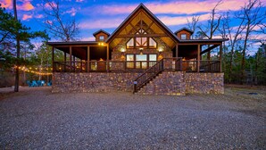 A rustic lodge with a stone facade, wooden beams, and a covered porch. - 5Kings | Pool Table, Shuffleboard, Playset, Putt Putt | 2min to New Casino! (Broken Bow)