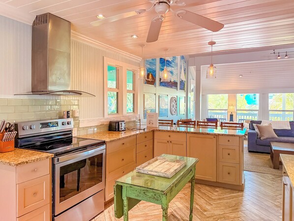 A kitchen with a built-in oven, a stove, and a dining area with a table and chairs.