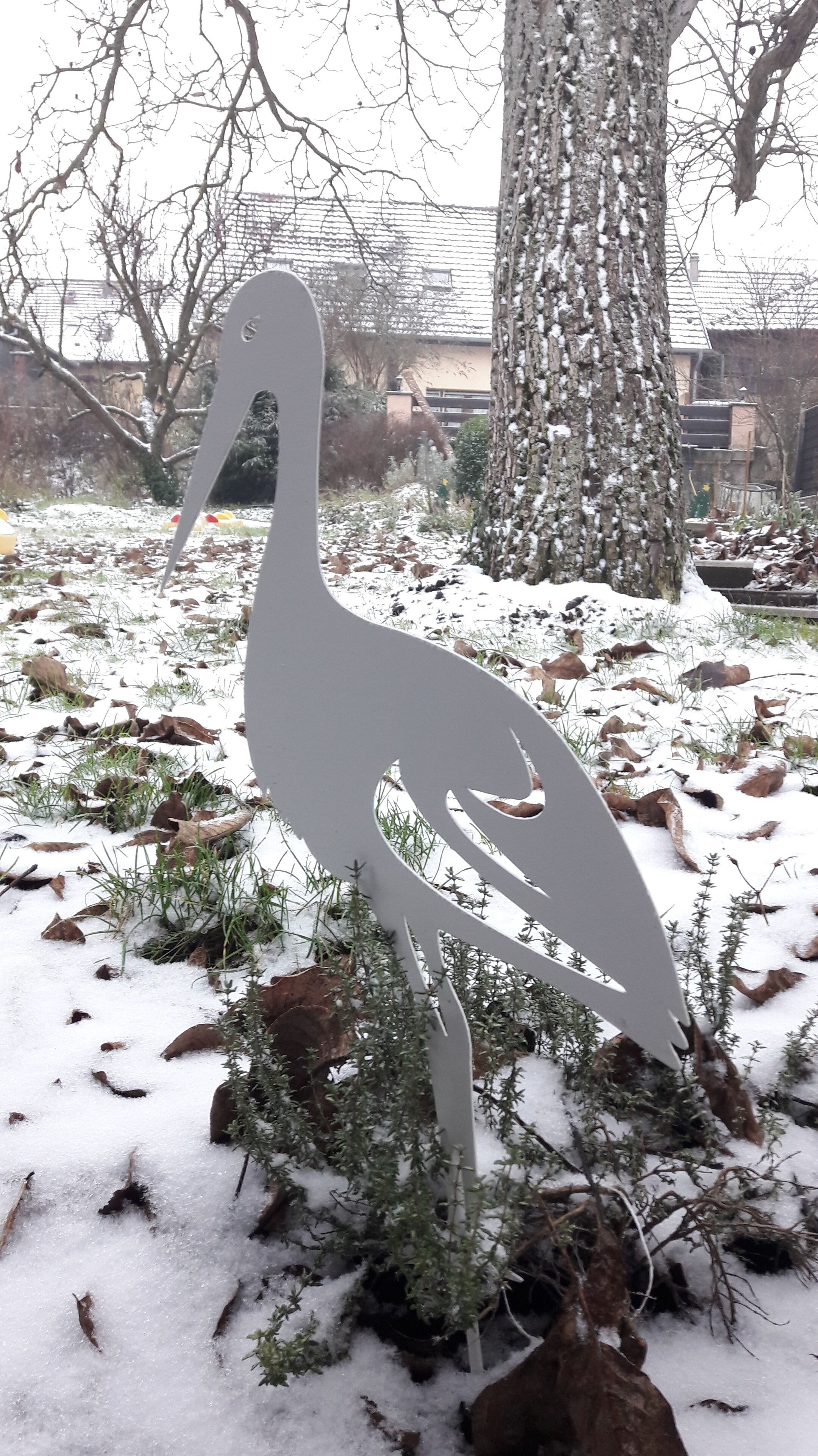 A sculpture of a bird in a snowy outdoor setting.