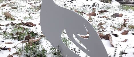 A sculpture of a bird in a snowy outdoor setting.