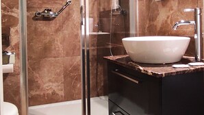 A modern bathroom with a glass-enclosed shower, a white sink, and a large mirror. - The Manoel Hotel (Valletta)