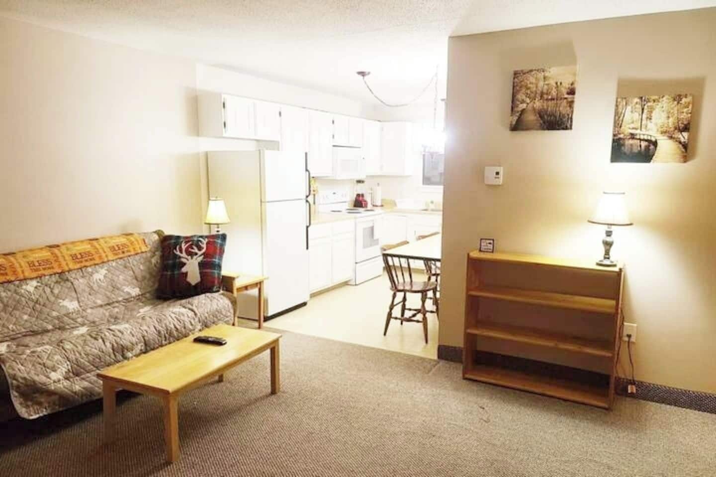 Een woonkamer met een bank, salontafel en een eethoek met een stoel en tafel.