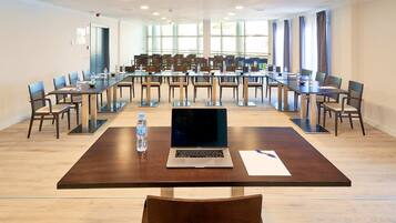 A conference room with a long table, chairs, and a laptop.