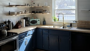 A modern kitchen with wooden cabinets, a stainless steel sink, and a built-in oven. - Historic Hudson Valley 1850 Brick Home (Saugerties)