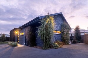 A modern house with a stone facade, a sloped roof, and a well-maintained garden. - Black Stilt Retreat, STUNNING luxury property (Twizel)