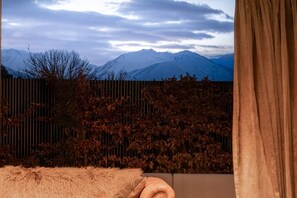 A room with a view of snow-covered mountains, a wooden fence, and a fur throw on the sofa. - Black Stilt Retreat, STUNNING luxury property (Twizel)