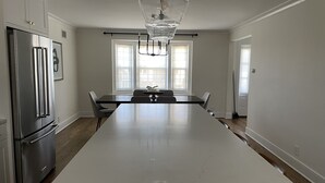 A modern kitchen with a large island, stainless steel appliances, and a chandelier. - Modern Colonial House  (Yonkers)