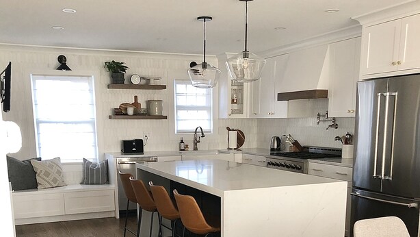 A modern kitchen with a central island, bar stools, a dining table, and a large refrigerator. - Modern Colonial House  (Yonkers)