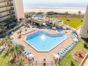 A resort pool area with multiple pools, lounge chairs, and a view of the beach. - Top Of The Gulf 213 (Panama City Beach)