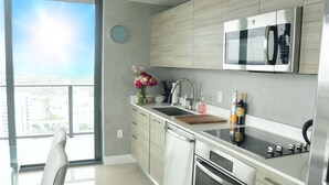 Una cocina moderna con electrodomésticos de acero inoxidable, un ventanal y vistas a la ciudad.