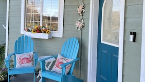 A porch with two blue Adirondack chairs, a blue door, and a window with a flower box. - Charming home on the Cliffs of Crescent City (Crescent City)