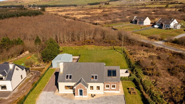 Une grande maison avec une allée spacieuse et une pelouse bien entretenue.