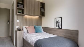 A bedroom with a bed, a built-in wardrobe, and a bedside table.