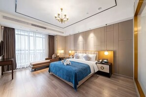 Une chambre d’hôtel moderne avec un grand lit, des tables de chevet, un bureau et une grande fenêtre avec des rideaux.
