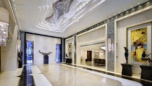 A spacious lobby with a polished floor, a chandelier, and abstract wall art. - Count Diamond Hotel (Longli)