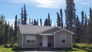 A single-story house with a sloped roof, a front porch, and a small front yard.
