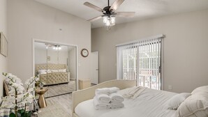 A bedroom with a bed, a ceiling fan, a large mirror, a window with blinds, and a potted plant. - Palm harbor/Crystal Beach 3/2 W Heated pool & Spa (Palm Harbor)