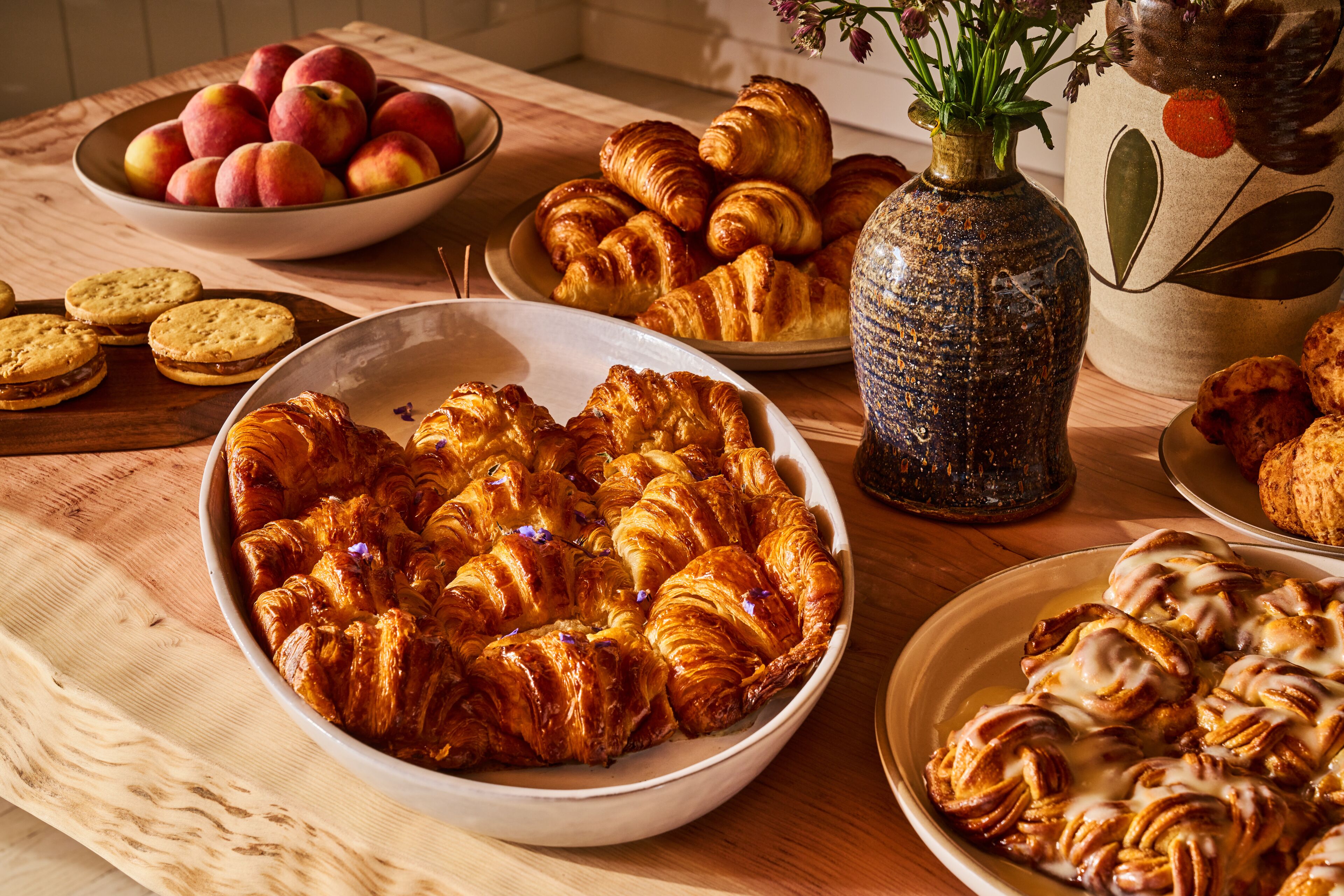 A table with various baked goods including croissants, cookies, and pastries.