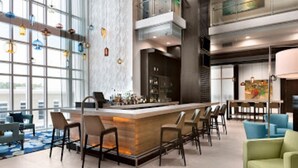 A modern bar area with a central bar, seating, and a view through large windows. - Luxury 2 Bedroom unit in beachfront Myrtle Beach resort Sleeps 8 (Myrtle Beach)