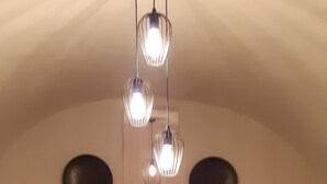 Uma sala de estar aconchegante com sofá, mesa de jantar e um candelabro.