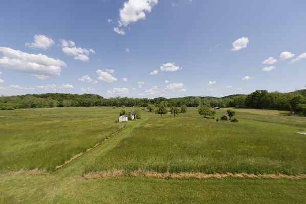 A wide, open field with a small building in the distance.
