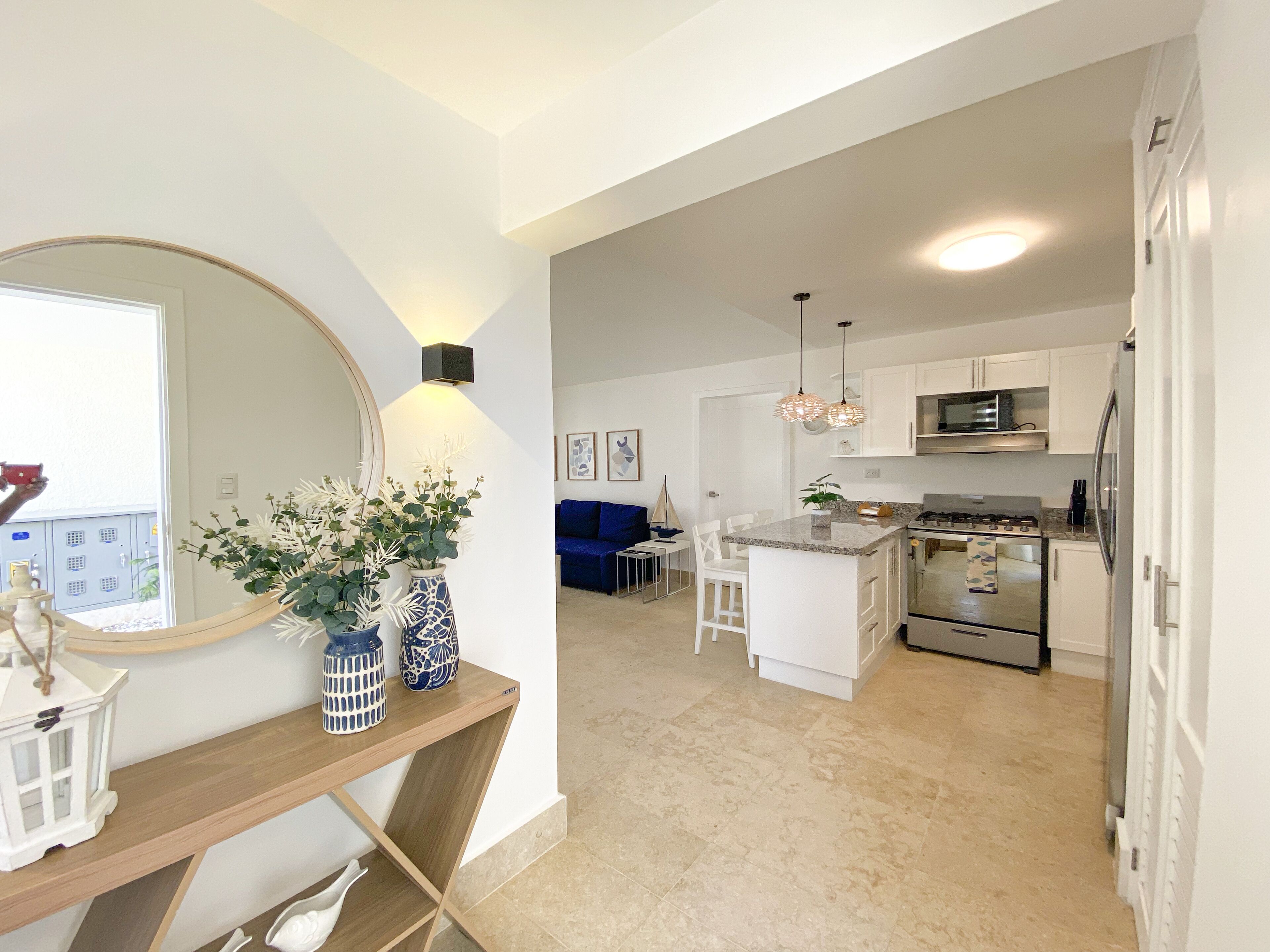 A modern kitchen with white cabinets, a central island, and stainless steel appliances.