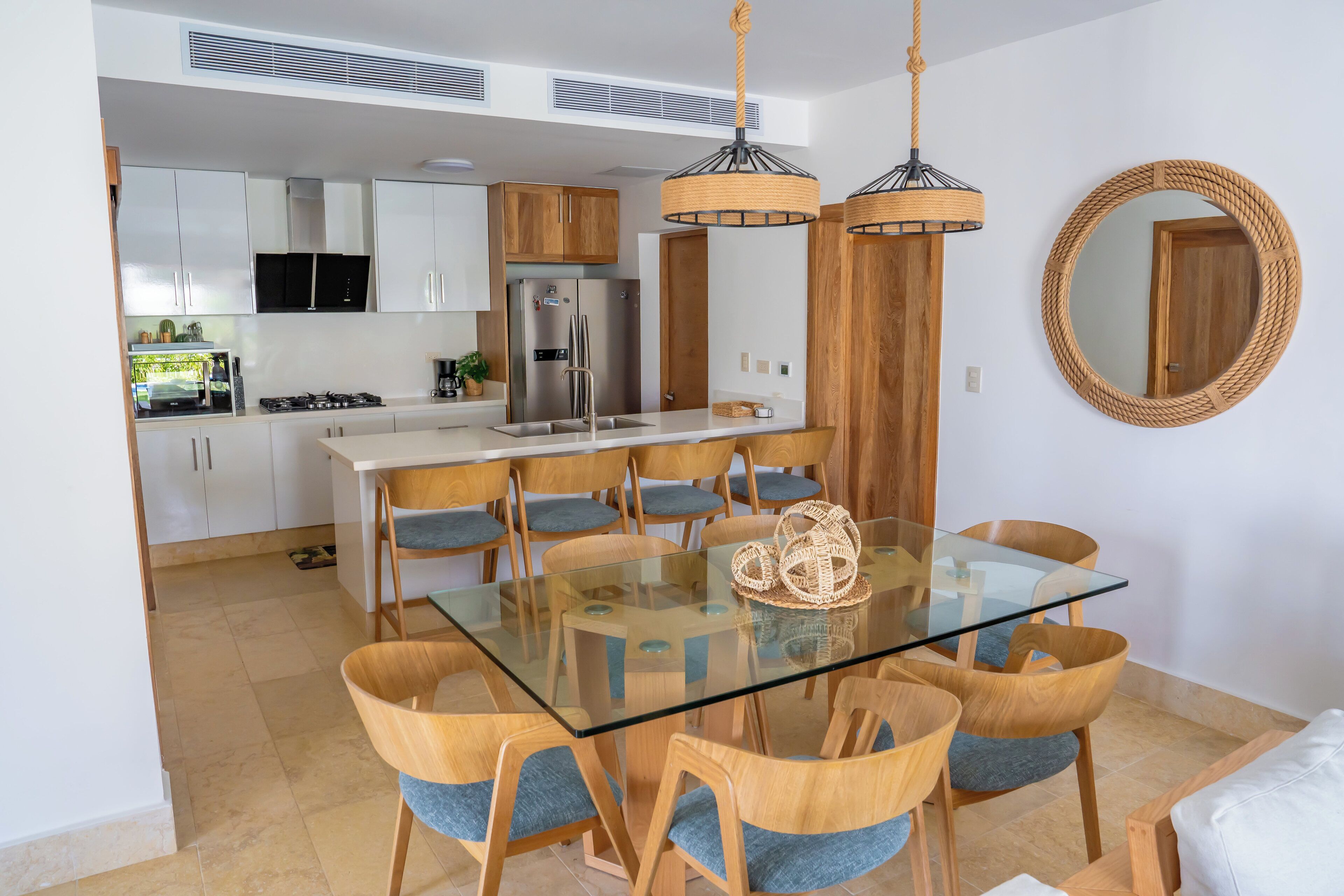 A modern kitchen with white cabinets, a stainless steel refrigerator, and a gas stove.