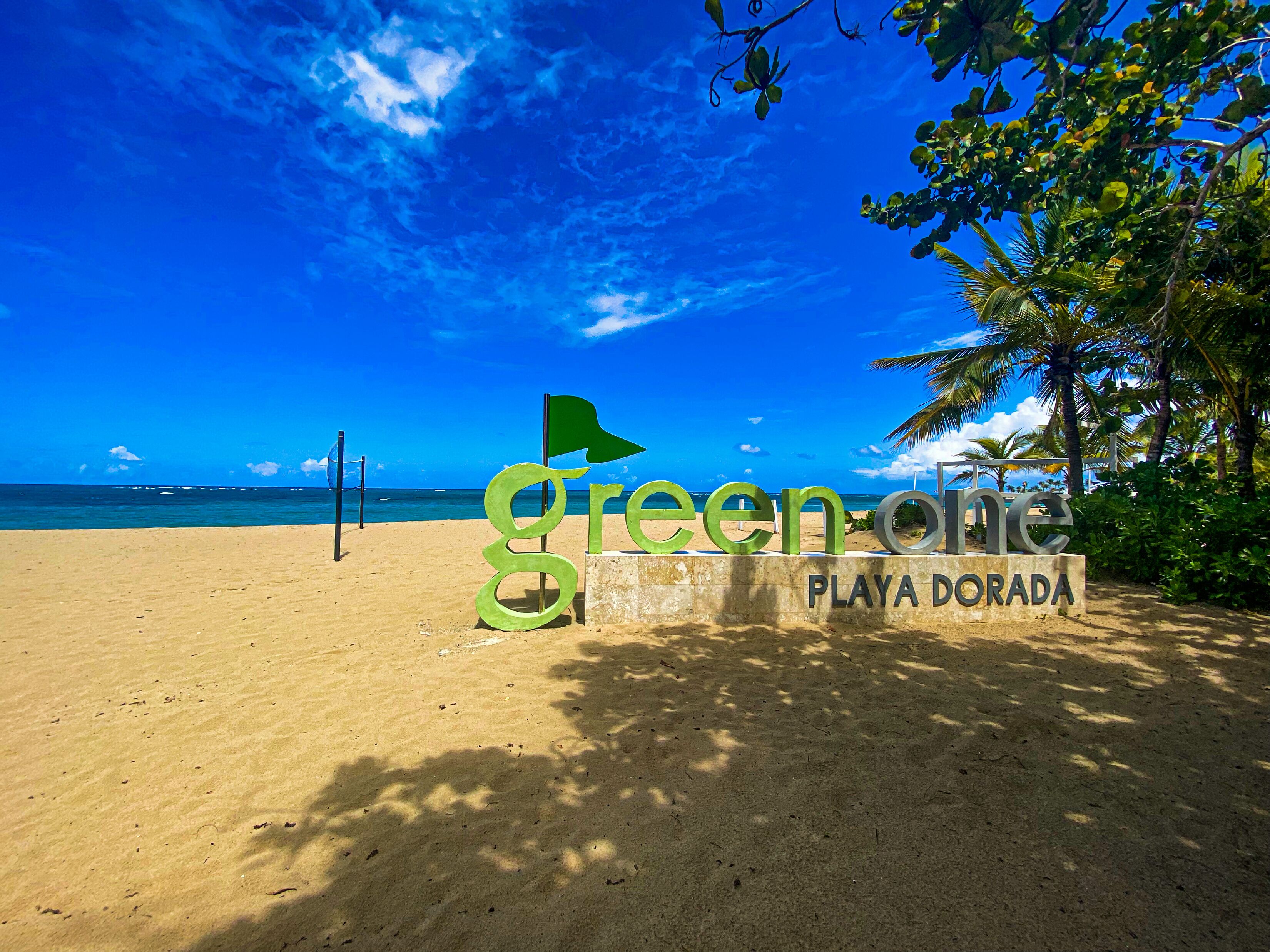 Una spiaggia con un cartello che recita 'green one Playa Dorada'.