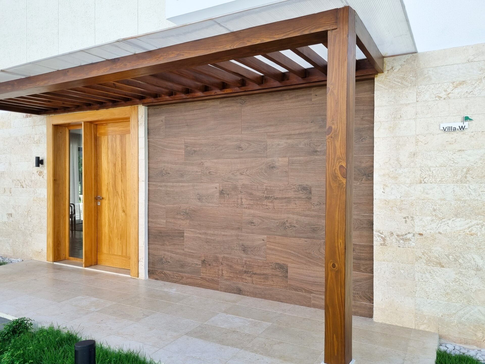 Un edificio con puerta de madera, puerta de garaje y un letrero que dice "villa-W".