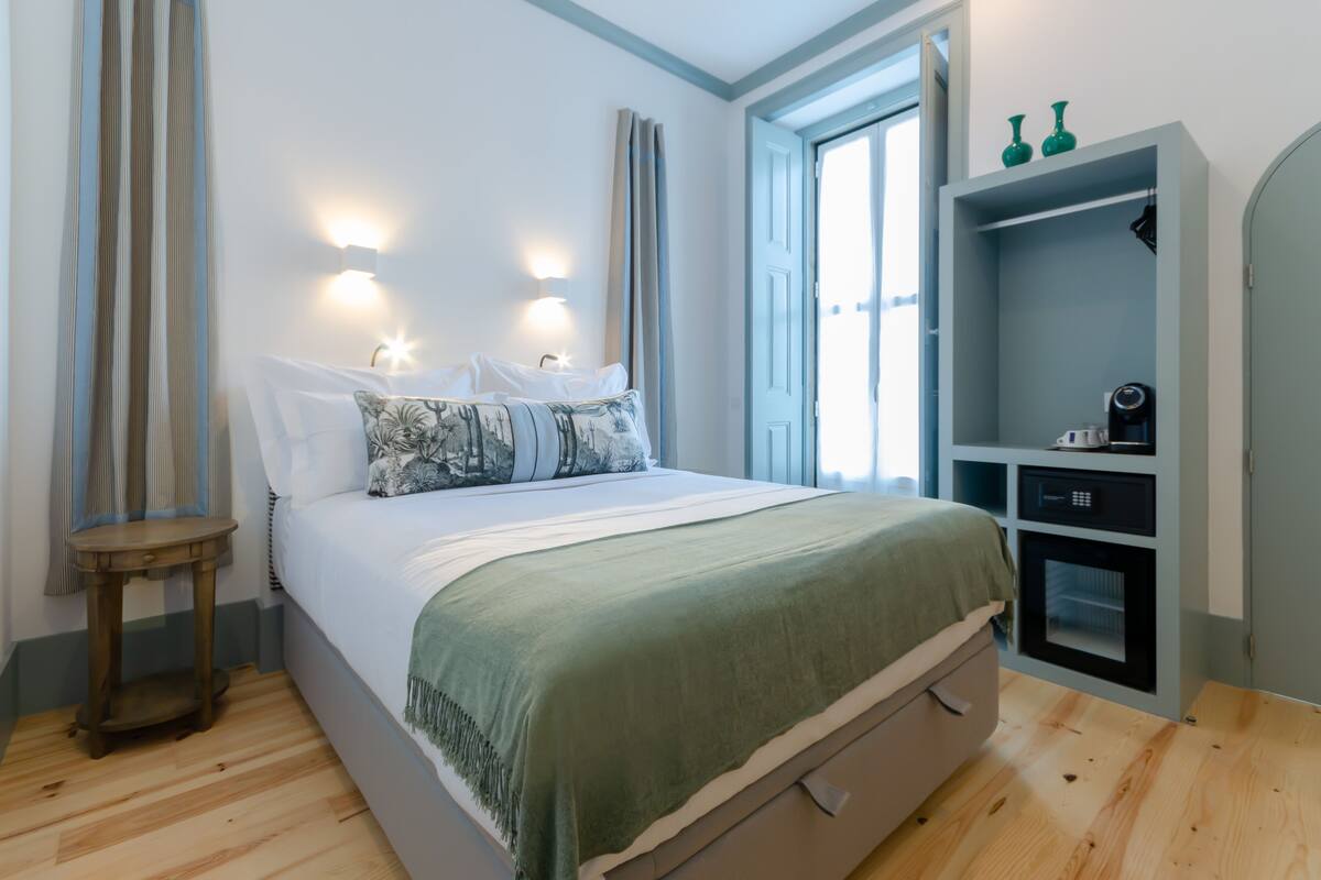 A bedroom with a bed, bedside tables, a wardrobe, and a window.