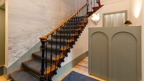 A staircase with a wooden handrail and grey carpeted steps. - Westlight Cascais Chalet - Adults Only. (Cascais)