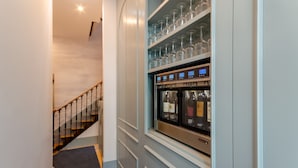 A staircase leading to a room with a wine refrigerator and shelves of wine glasses. - Westlight Cascais Chalet - Adults Only. (Cascais)