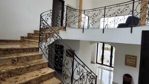 A marble staircase with ornate black railings leading to a second floor. - Palace of Dreams, Ultra-Modern Spanish Estate, Spectacular Views.  Hot Springs. (San Antonio)