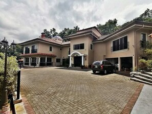 A two-story house with a paved driveway and a parked car.