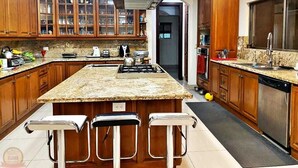 A kitchen with wooden cabinets, a granite countertop, a gas stove, and a dishwasher. - Palace of Dreams, Ultra-Modern Spanish Estate, Spectacular Views.  Hot Springs. (San Antonio)