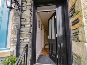 A stone facade with a black door and a sign reading "The Havenwell."