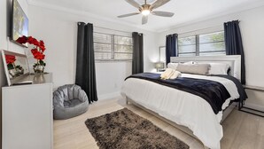 A bedroom with a bed, a ceiling fan, a bedside table, a lamp, a chair, and a rug. - Brand New Renovated COZY Home! Prime Location! Live in Style 🏡🌟⭐️💫 (Miami)
