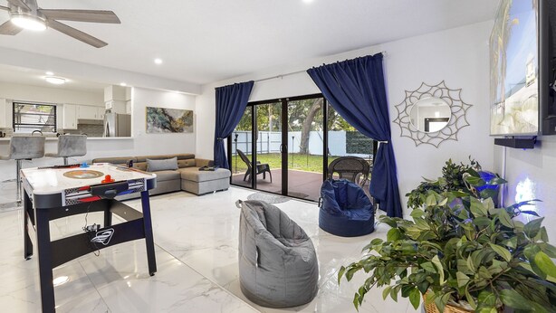 A modern living room with a foosball table, a bean bag, and a large potted plant. - Brand New Renovated COZY Home! Prime Location! Live in Style 🏡🌟⭐️💫 (Miami)
