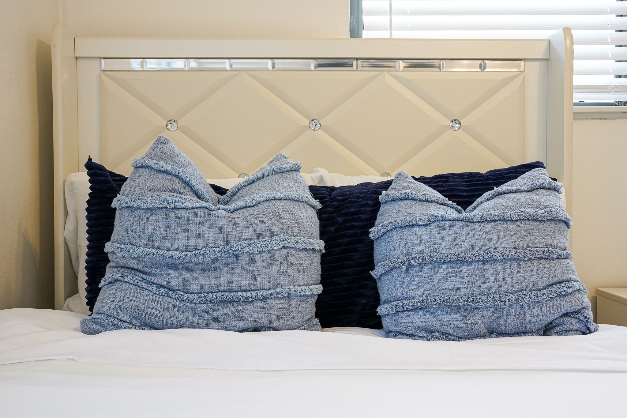 A bed with a tufted headboard and two pillows.